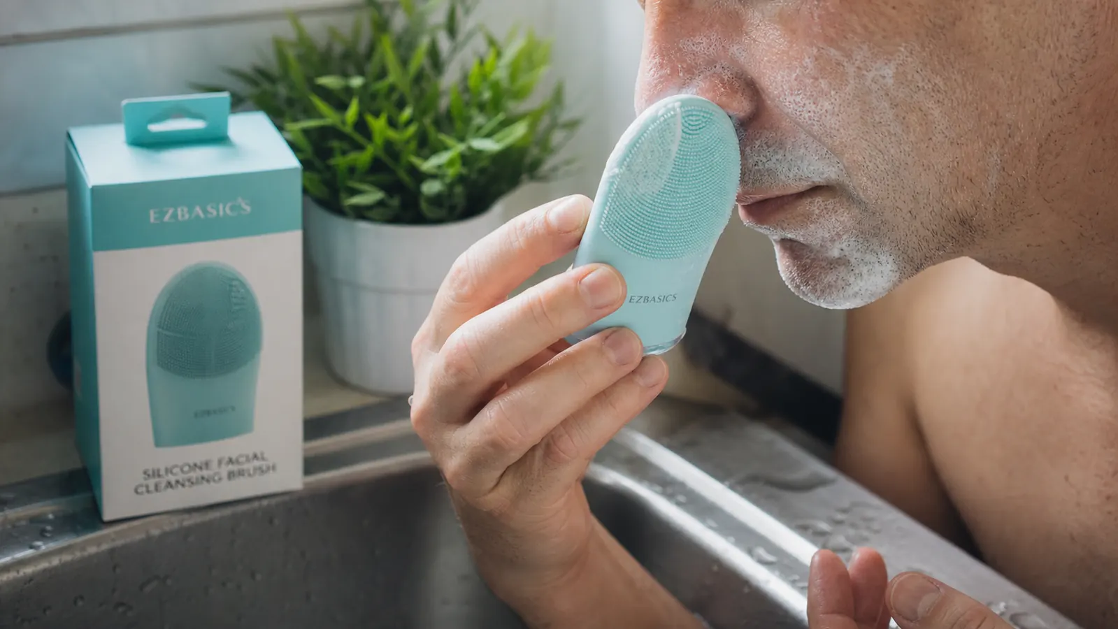 Close-up of a hand pressing a silicone cleansing brush in slow circles along the side of the nose and chin, foam visible