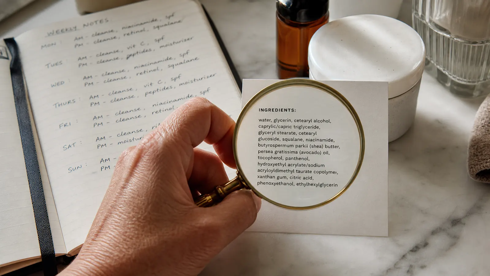 Close-up of a hand holding a magnifying glass over a small ingredient label on a counter